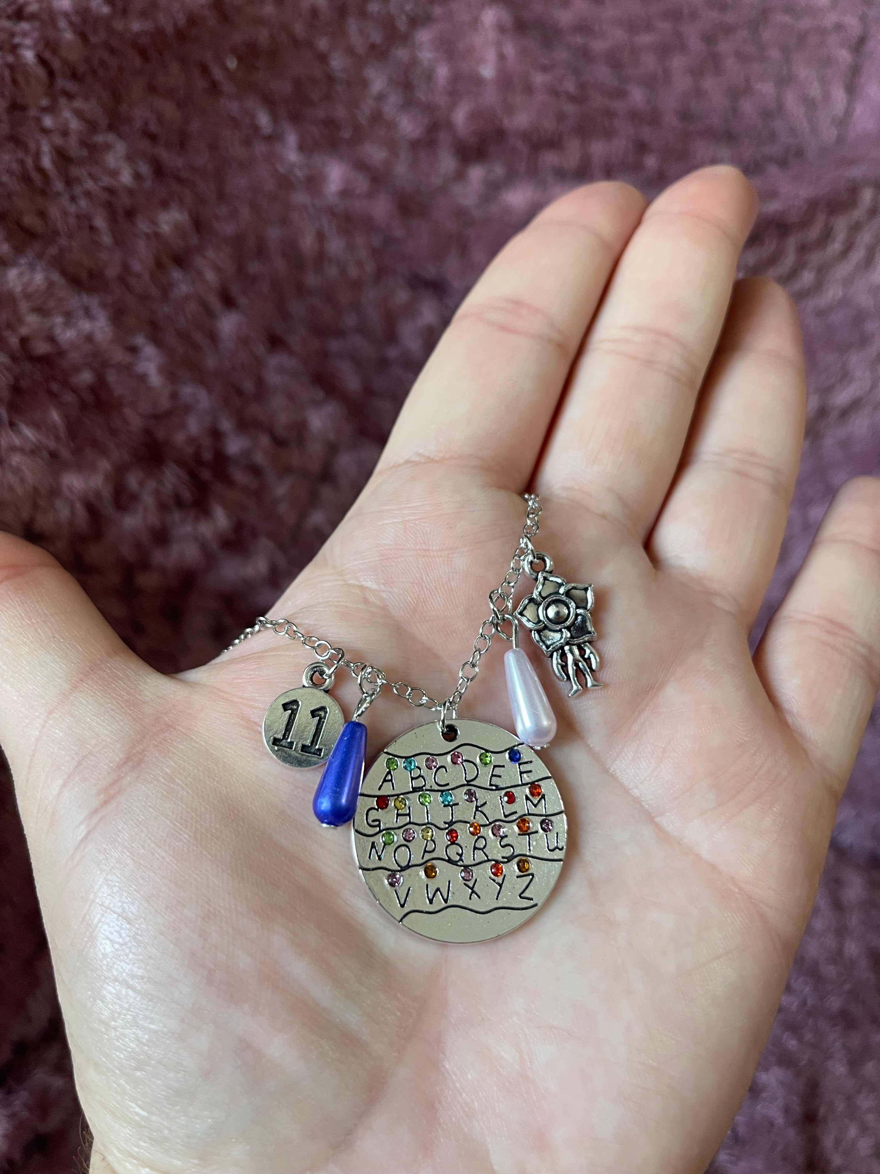 Stranger Things: Collar Abecedario con Luces - Set con Dijes de 11 y Demogorgon